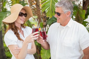 Holidaying couple toasting with cocktails