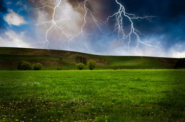 Fotobehang Thunderstorm with lightning in green meadow. © klagyivik