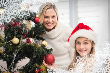 Mother and daughter decorating christmas tree