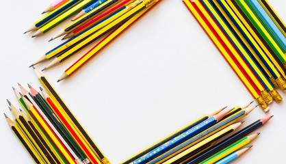 Fototapeta premium colorful pencils on the white paper, view from above