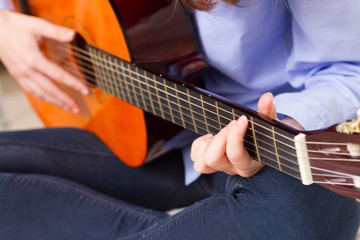 Closeup young girl playing guitar