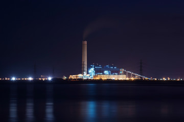 Fototapeta na wymiar Power plant factory silhouette over sunset