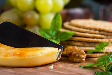close view on cheese with oat cakes and walnut on board