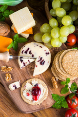 top overhead view on cheese board with grape oat cakes and cranb