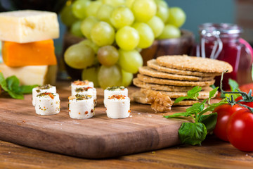 small cheese snacks with cakes and grapes