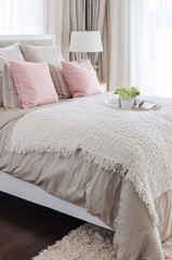 pink pillows on bed with white tray of flower at home