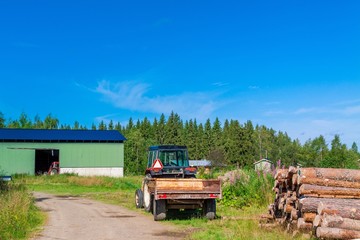 old rusty tractor with firewood in the barn