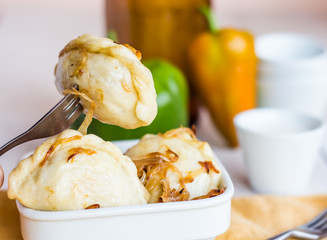 Fork dumplings with potatoes, fried onions and sour cream, Ukrai