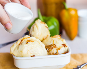 Fork dumplings with potatoes, fried onions and sour cream, Ukrai