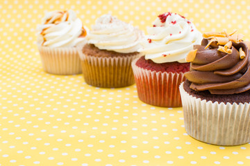 Cupcakes on yellow polka dot background