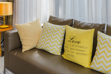 brown sofa with yellow pillows