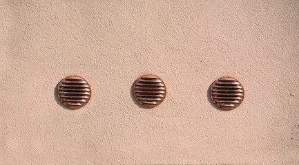 three air intakes in a rustic wall