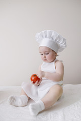 cute little cook eats tomato