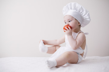 cute little cook eats tomato
