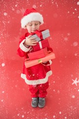 Composite image of cute little boy in santa costume