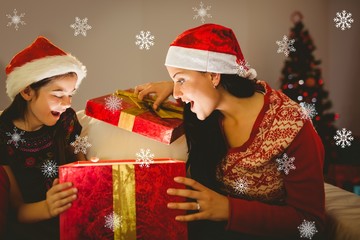 Mother and daughter opening a glowing gift