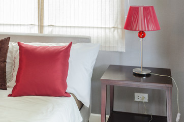 bedroom with red pillow and red lamp