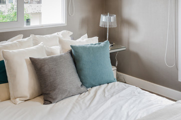 modern bedroom with pillows on white bed