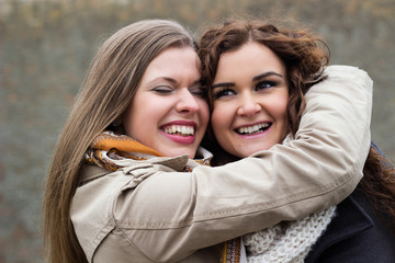 Portrait of two young beautiful women smiling and embracing