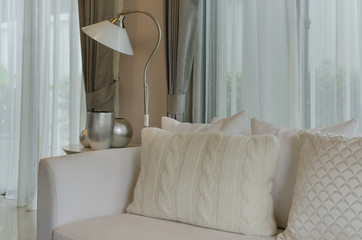 white living room with white pillows on white sofa