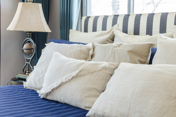 pillows on blue bed with lamp