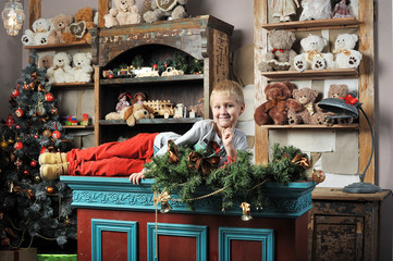 Christmas boy around the Christmas tree with gifts and toys Tedd