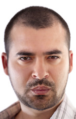 Fototapeta premium Close up view of a young man's face with short hair and beard.