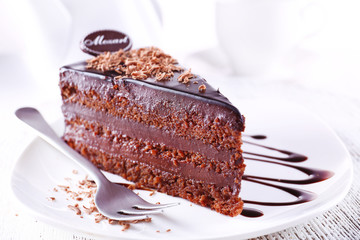 Delicious chocolate cake on plate on table on light background