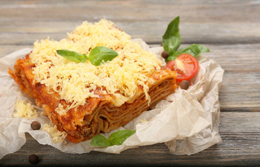 Portion of tasty lasagna on wooden table
