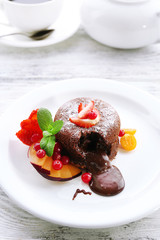 Hot chocolate pudding with fondant centre with fruits, close-up