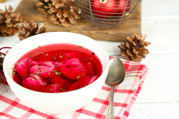 Traditional polish clear red borscht with dumplings in bowl