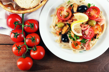 Tasty pasta with shrimps, mussels, black olives and tomato