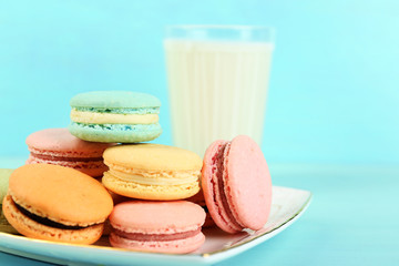 Assortment of gentle colorful macaroons and glass with milk