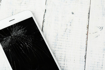 Broken iPhone on wooden background