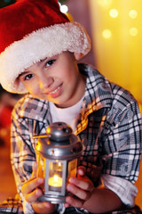 Little boy sitting near fireplace in room