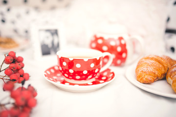 Closeup of red dots coffee cup and croissants as breakfast