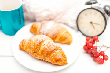 Croissant and coffee as breakfast in bed on an sunday morning