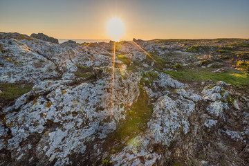 Sunset on colored granite and schist rock face