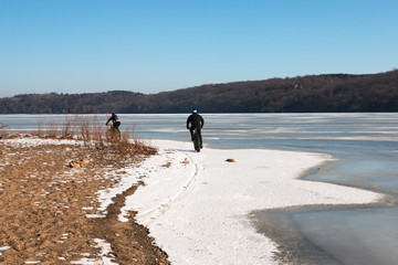 Men riding fat-bikes along frozen Mississippi River