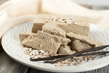 Sunflower halva on plate, on wooden background