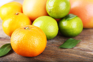 Ripe citrus with green leaves on wooden background