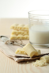 Tasty white porous chocolate and glass of milk,