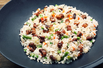 Tasty rice preparing in wok, close-up