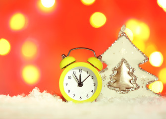 Fototapeta na wymiar Alarm clock with Christmas decorations on bright background