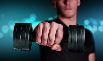 Fitness man with dumbbell, focus on dumbbell