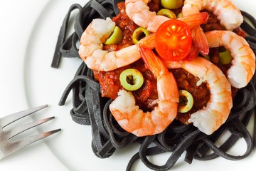 Black pasta with tomato sauce and shrimp, closeup