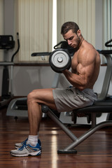 Fototapeta na wymiar Male Athlete Doing Heavy Weight Exercise For Biceps