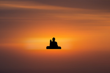 Naklejka na ściany i meble silhouette of buddha and sunset background with blur motion
