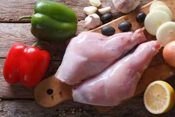 Raw meat rabbit legs and vegetables close-up top view