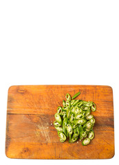 Chopped green chili peppers on wooden cutting board 